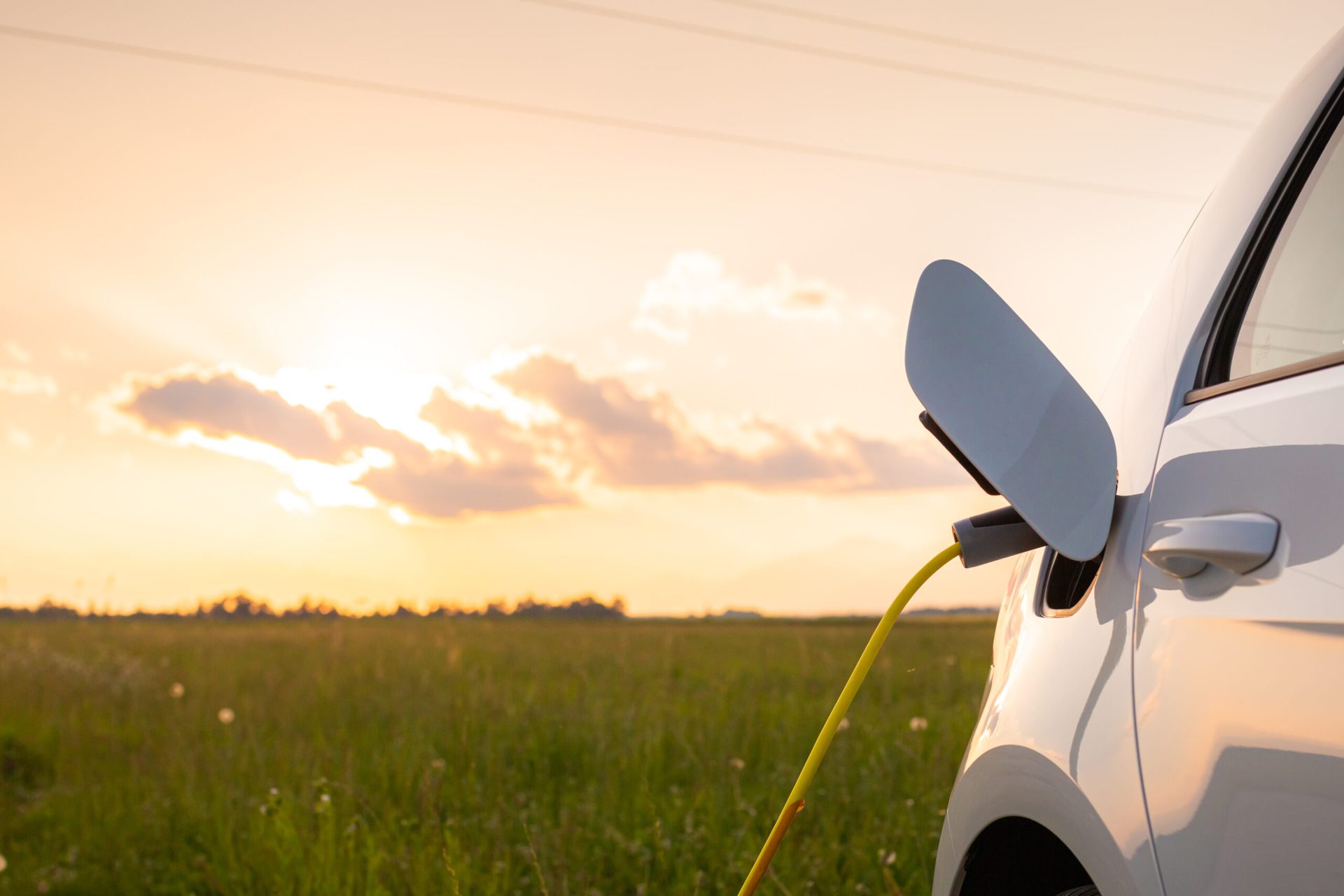 Voiture électrique en charge au coucher du soleil